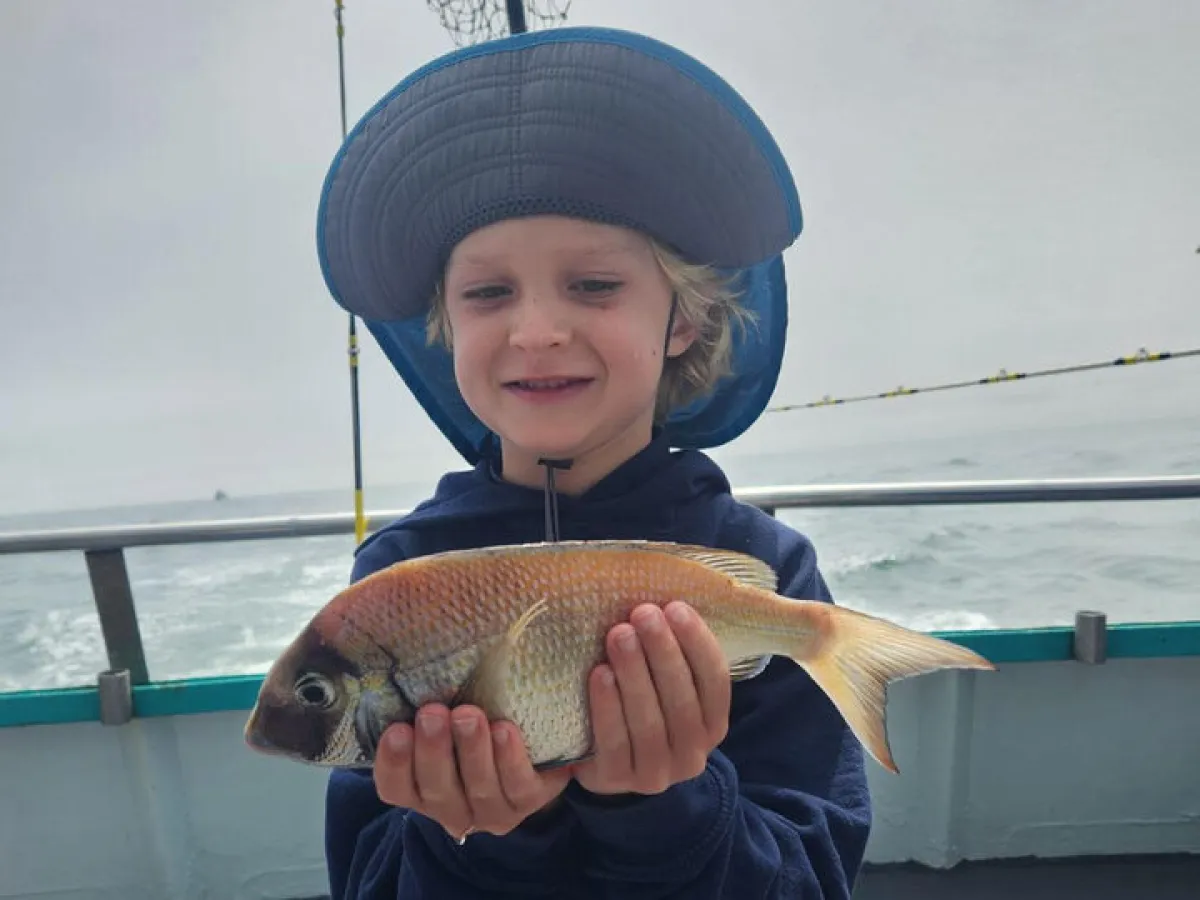 a young boy holding a fish