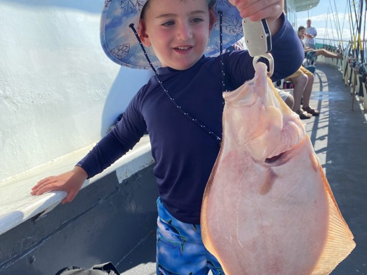 a young boy holding a fish