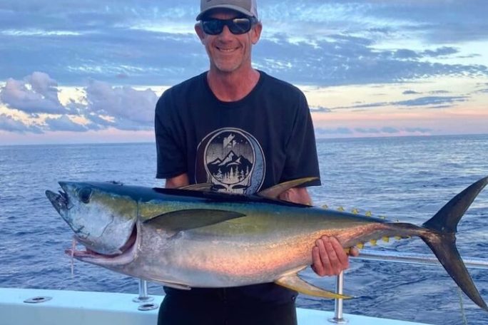 a man holding a fish in the water