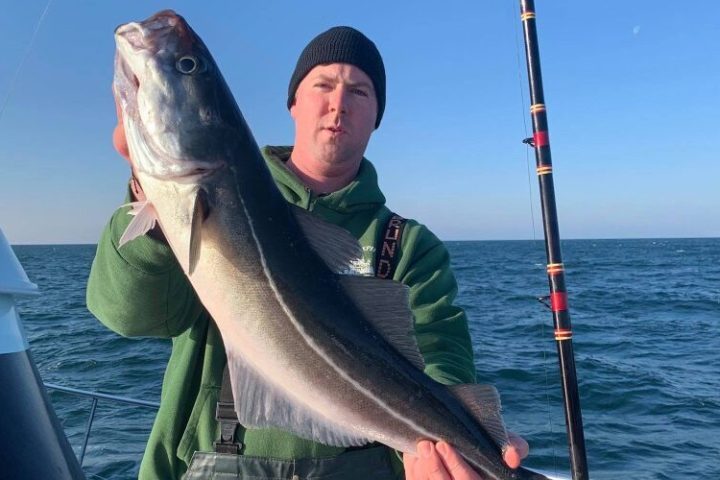 Orion McCabe holding a fish in the water