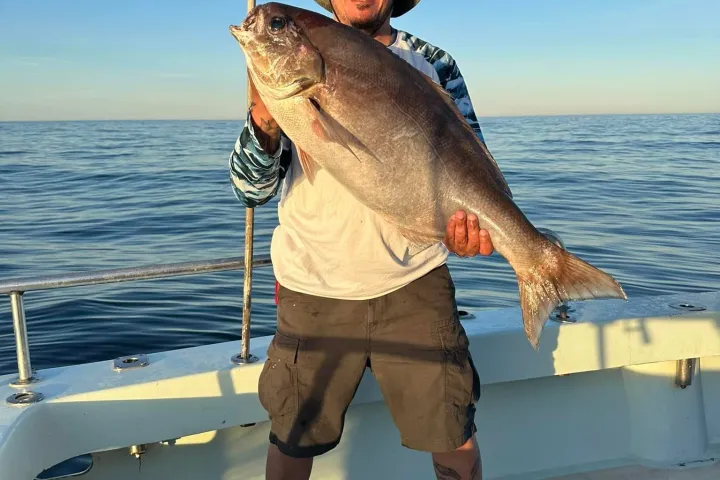 a man standing next to a body of water