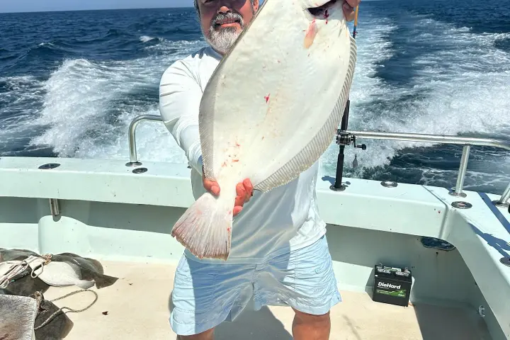 a man holding a fish in the water