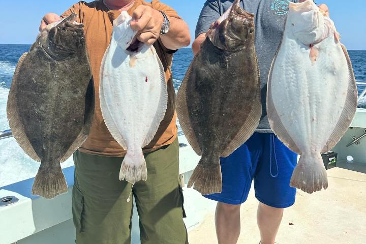 a group of people standing next to a man holding a fish
