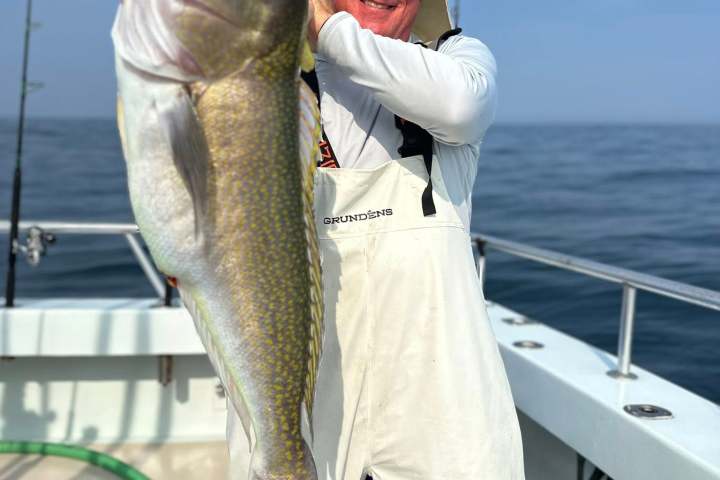 a man holding a fish on a boat