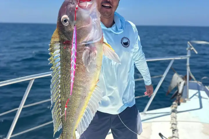 a man holding a fish in the water