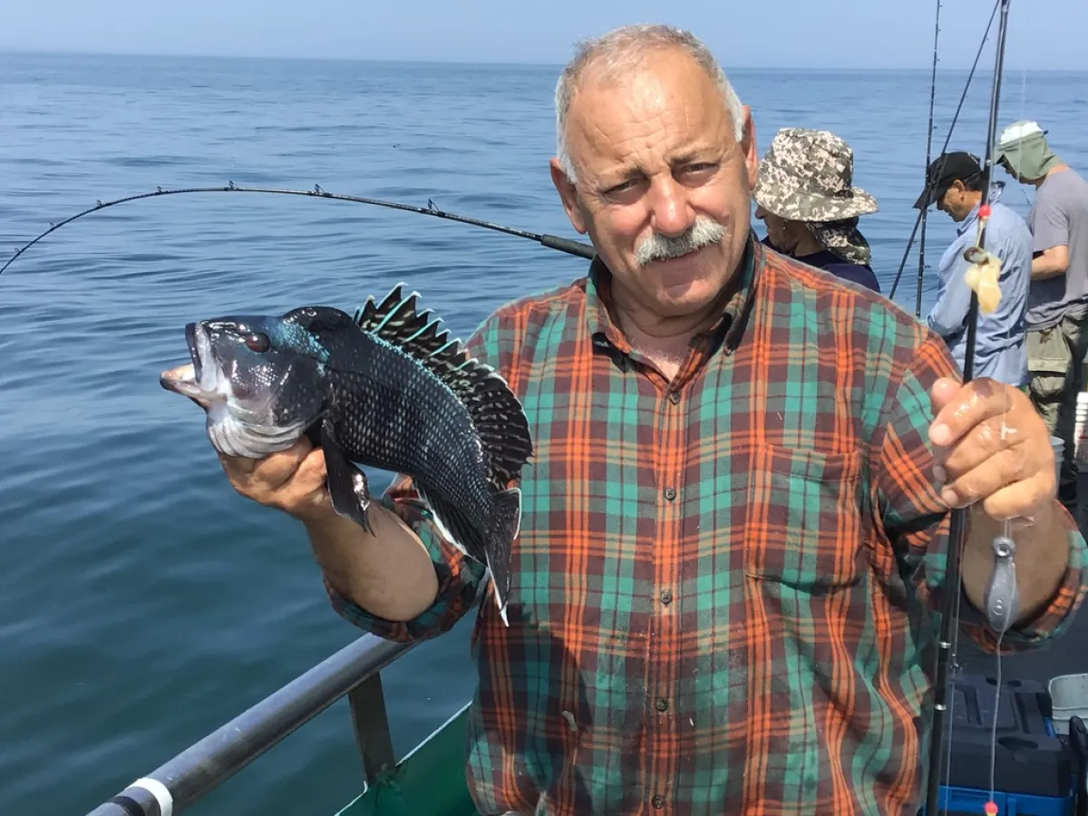 a man standing next to a body of water