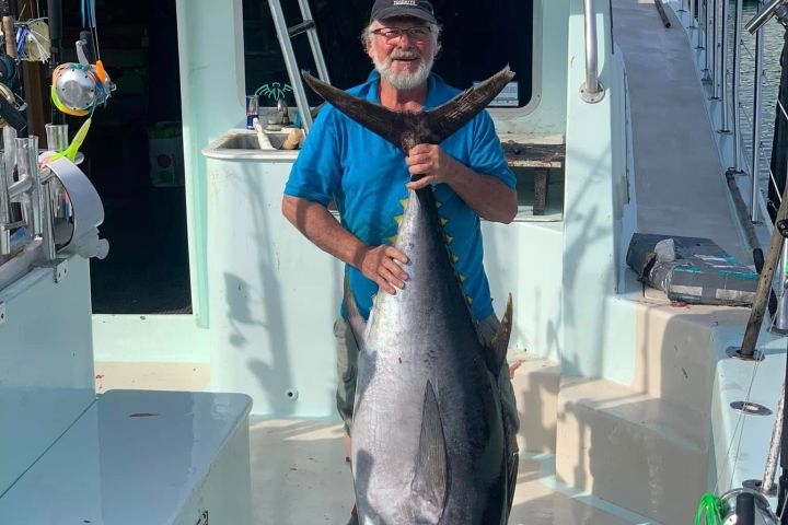 a man holding a fish on a boat