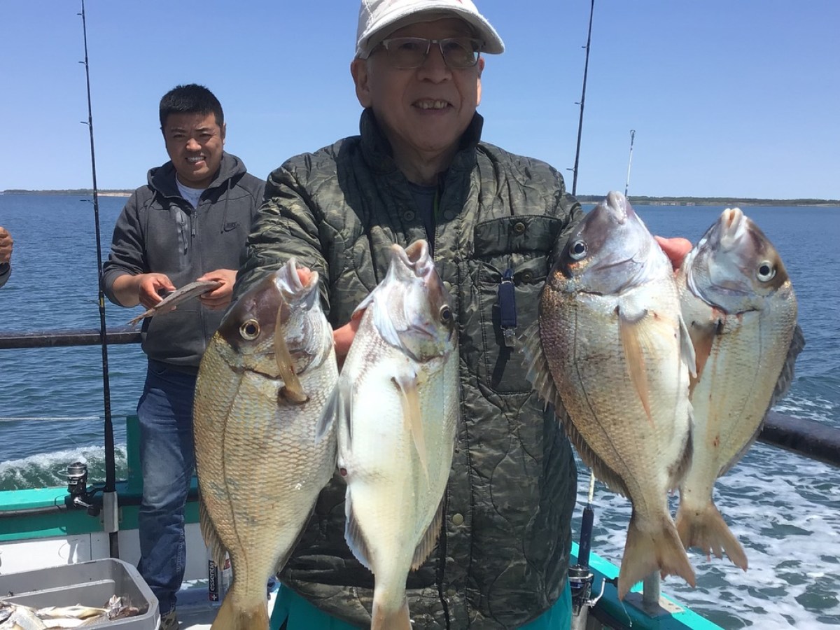 a man holding a fish on a boat