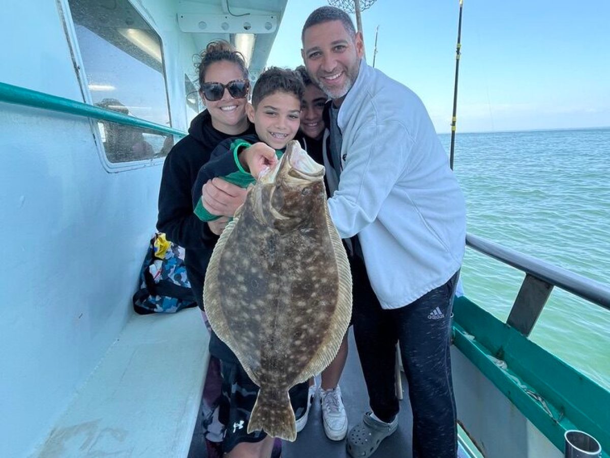 a man holding a fish on a boat