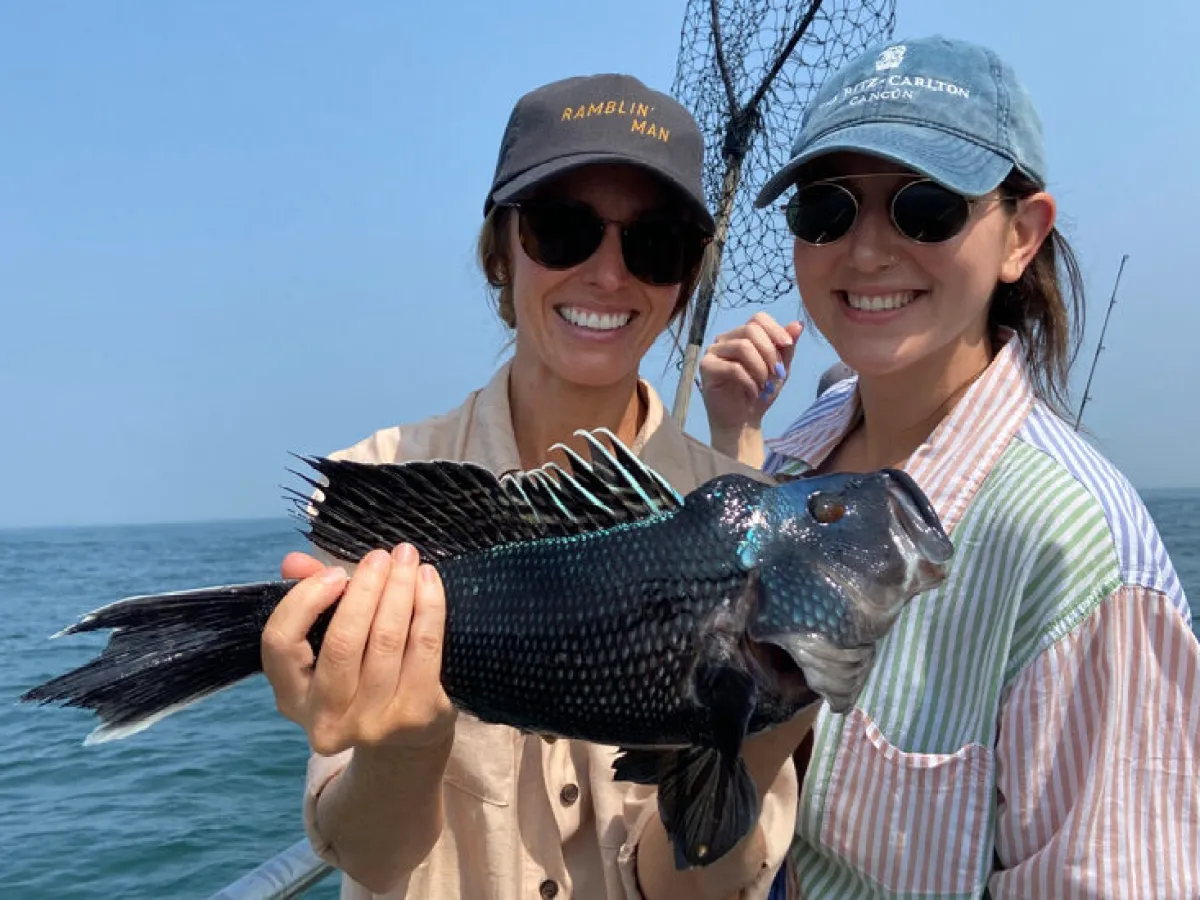 a man and a woman standing next to a body of water