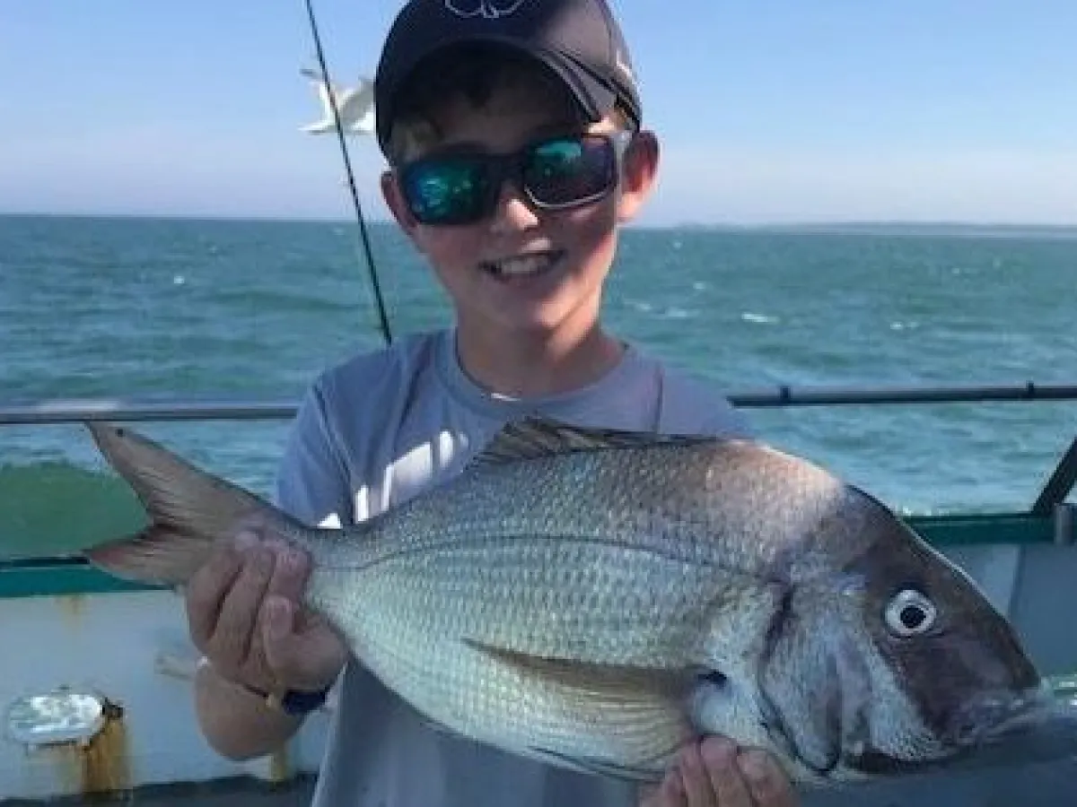 a man holding a fish in the water