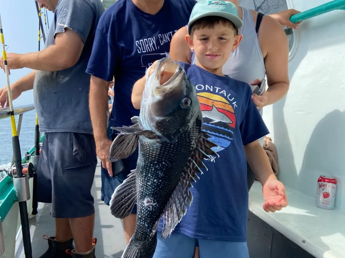 a group of people standing next to a person holding a fish