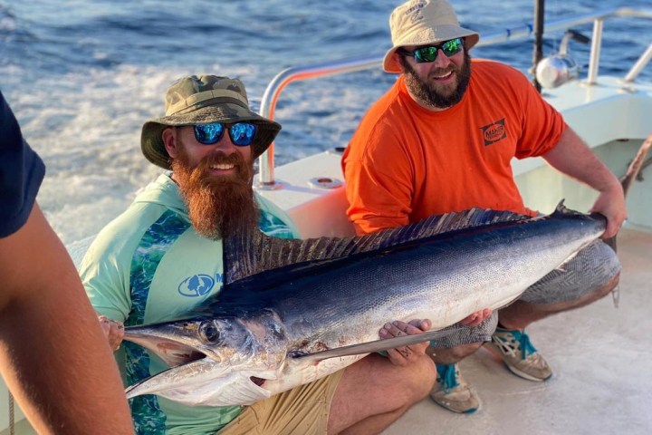 a person holding a fish in the water