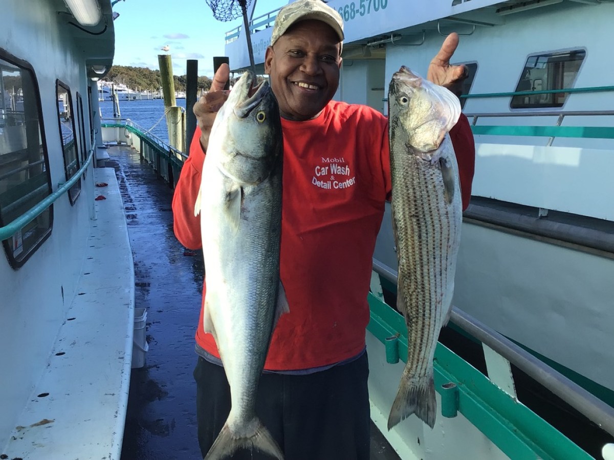 a man holding a fish on a boat