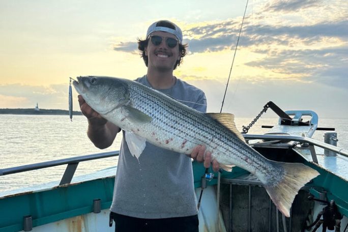 a person holding a fish on a boat in the water