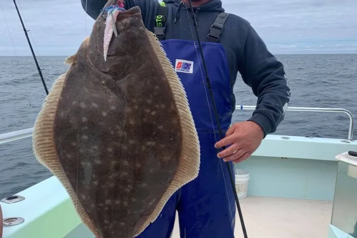 a man holding a fish on a boat