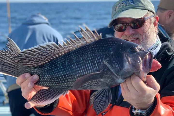 a man holding a fish in the water