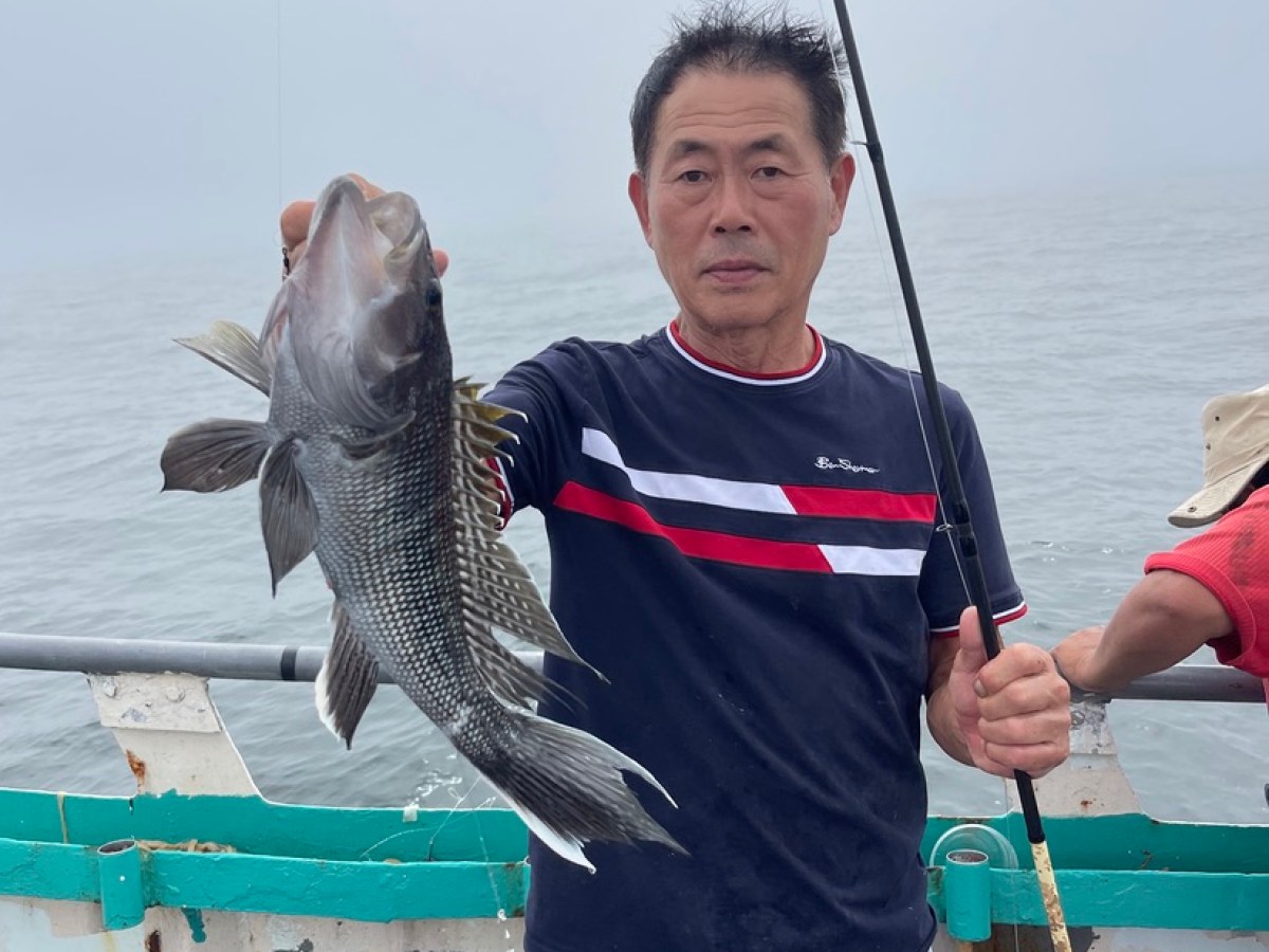 a man holding a fish on a boat