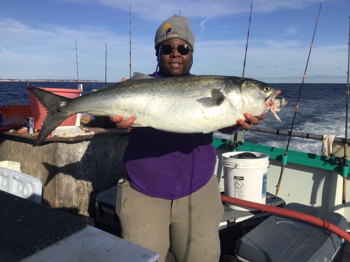 a man holding a fish on a boat