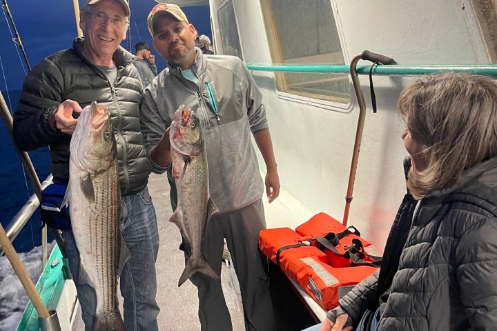 a group of people standing in front of a fish