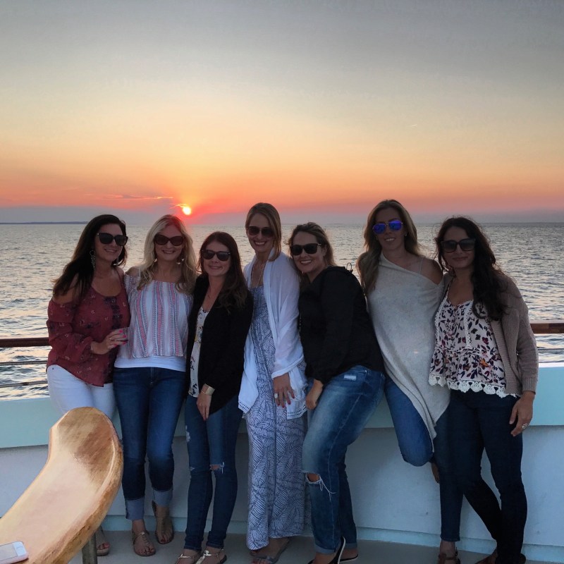 a group of people standing next to a body of water