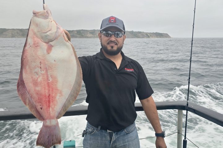 a man holding a fish on a boat