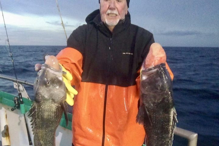 a man holding a fish in the water