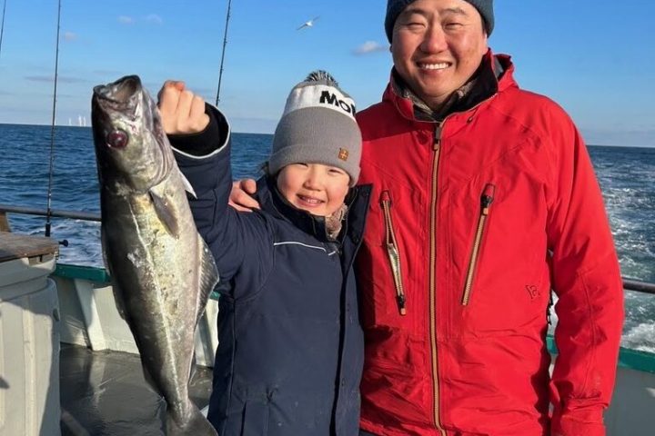 a person holding a fish posing for the camera