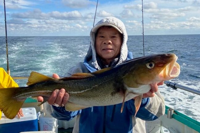 a person holding a fish on a boat
