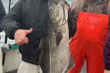 a group of people standing in front of a fish