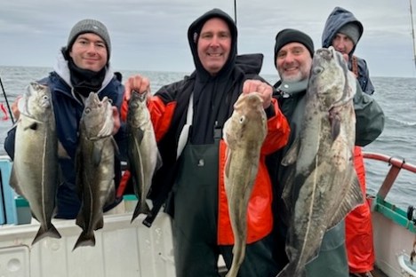 a group of people posing for a fish