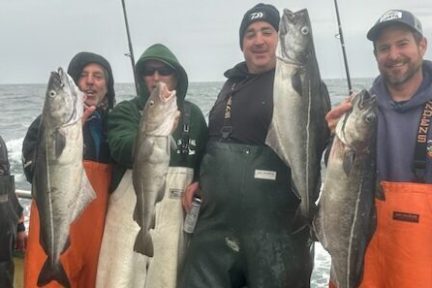 a group of people posing for a fish