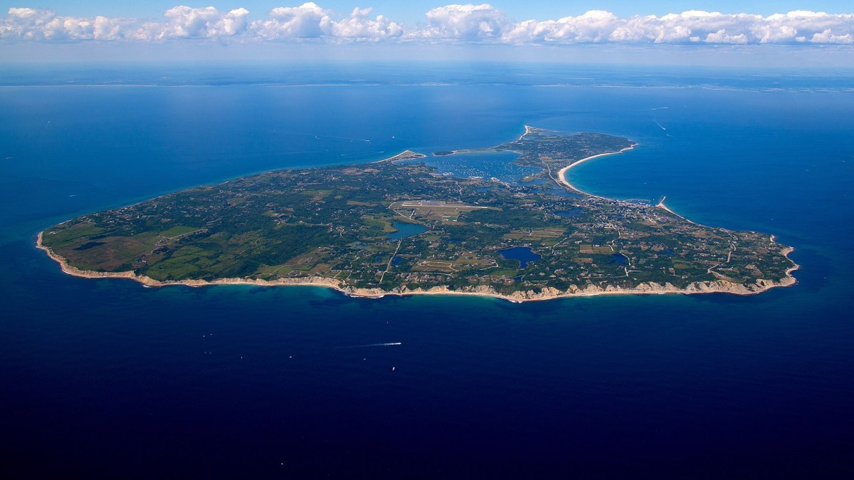 1920px-HiRes_BlockIsland_Aerial_7-23-2015 a view of a large body of water with a mountain in the background