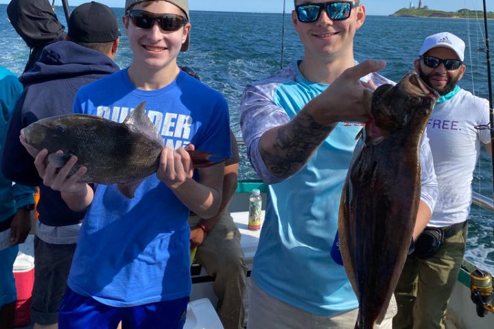 a group of people standing next to a person holding a fish