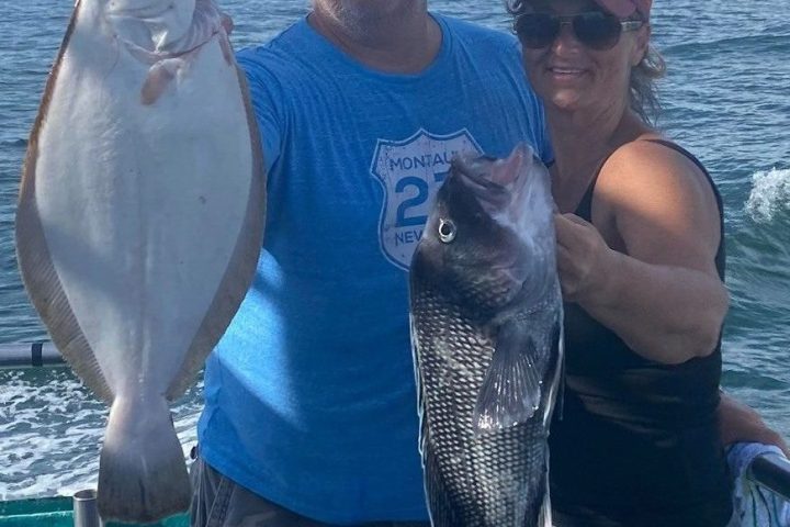 a man holding a fish on a boat in the water