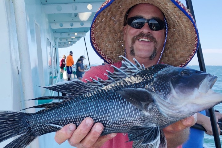 a man holding a fish in the water