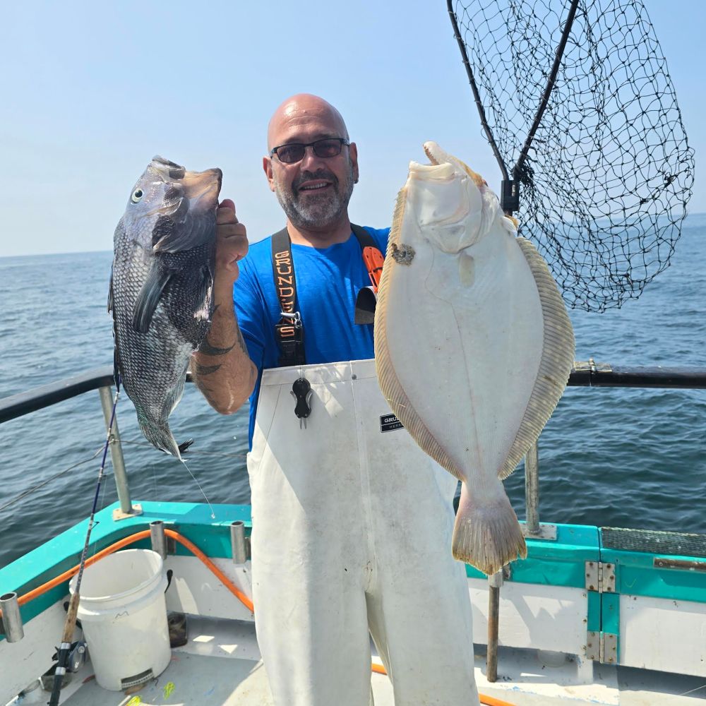 a man holding a fish on a boat in the water