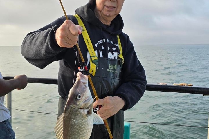 a person holding a fish on a boat in the water