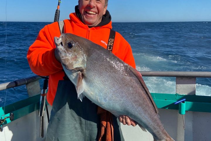a person holding a fish in the water