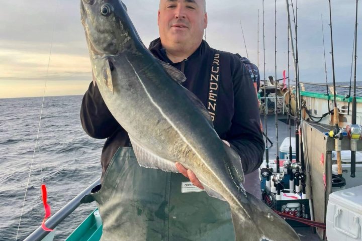 a man holding a fish in the water