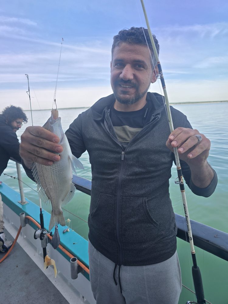 a man holding a fish in the water
