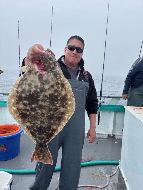 a man holding a fish on a boat