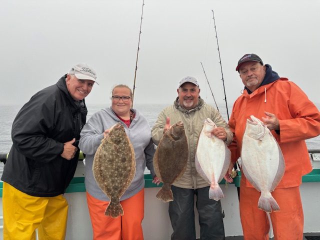 a group of people standing next to a man holding a fish